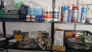 Prateleiras com colas, selantes e discos para ferramentas.