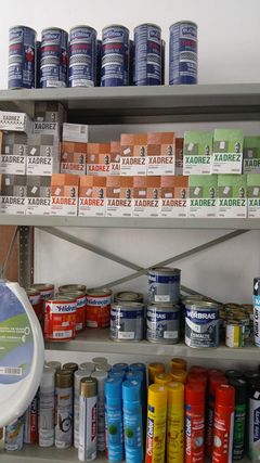 Prateleiras com pigmentos, latas de tinta e tintas em spray.